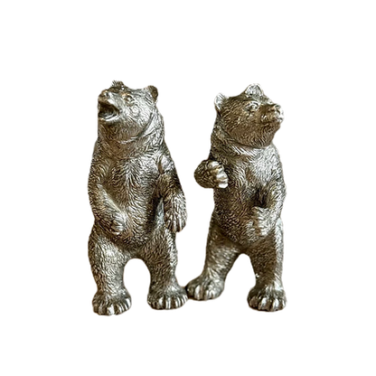 Close-up of two pewter bear shakers showing textured fur and raised paws