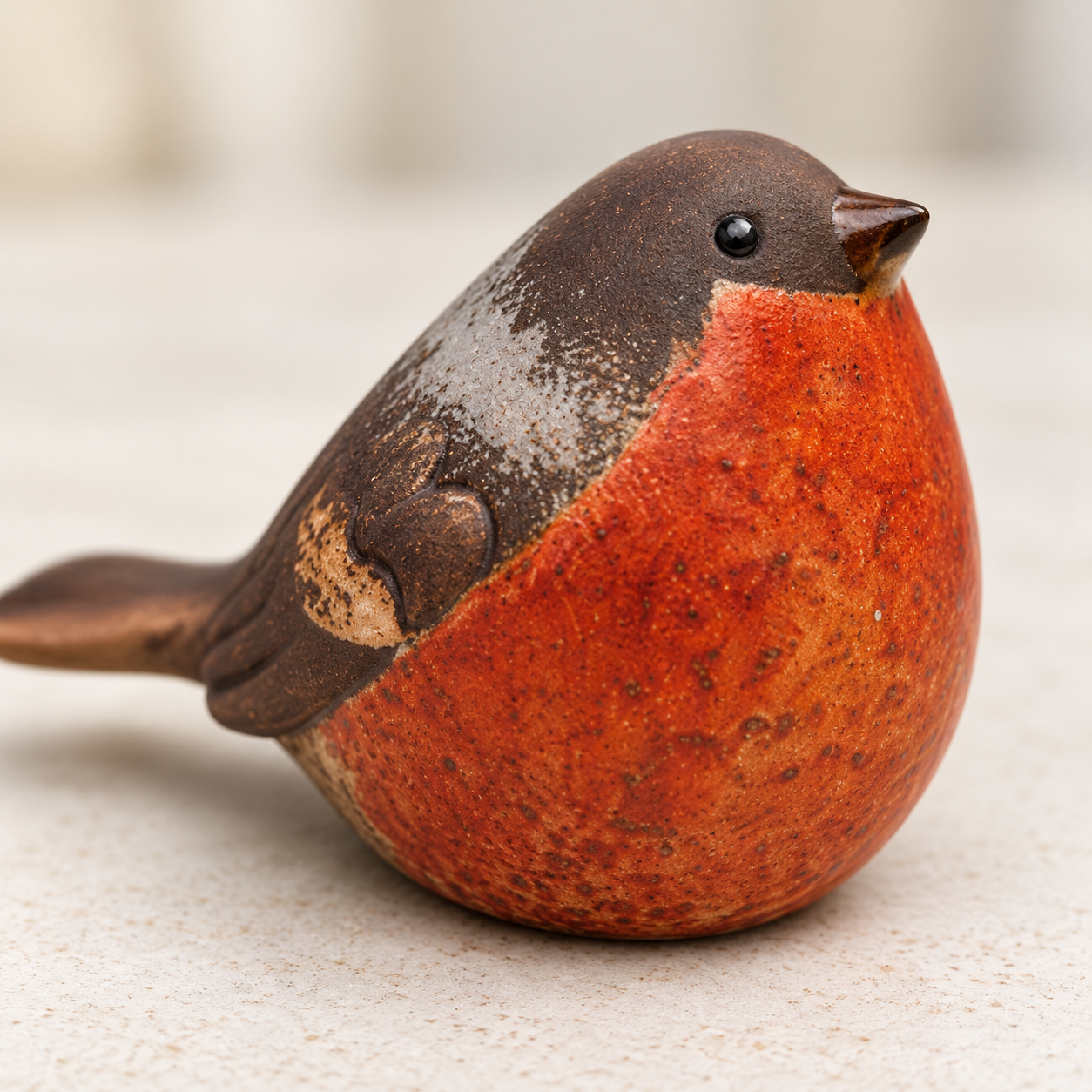 Close-up of the speckled orange-red breast and ceramic feather detail