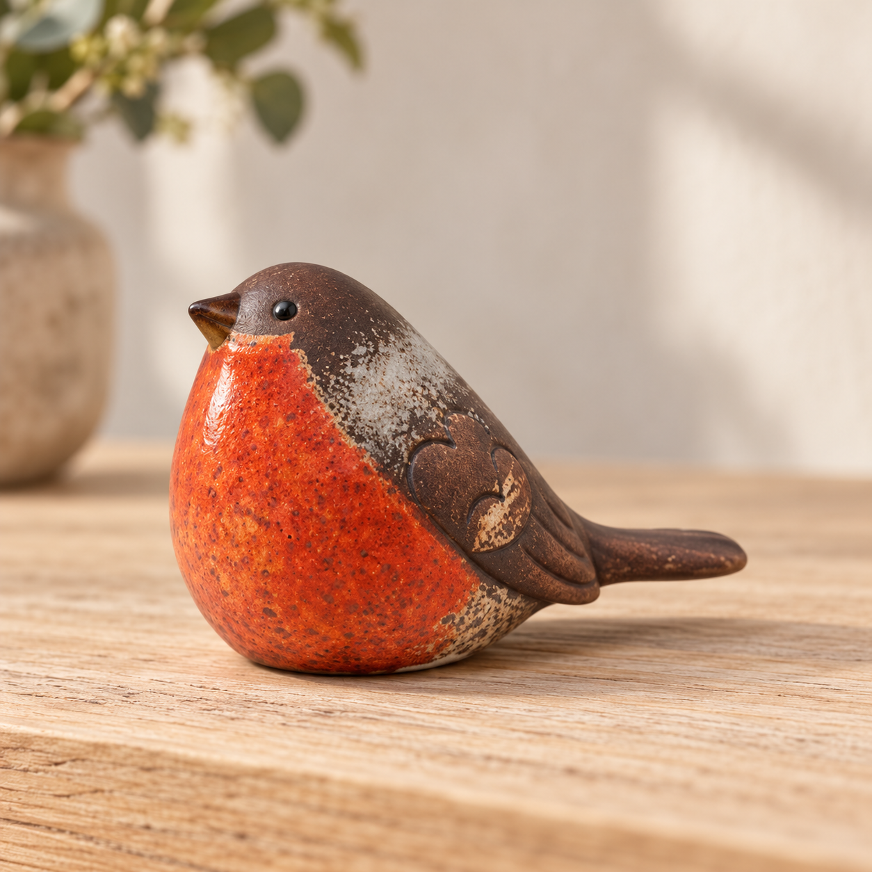 Side profile of a traditional matte ceramic robin showing its brown wing and tail