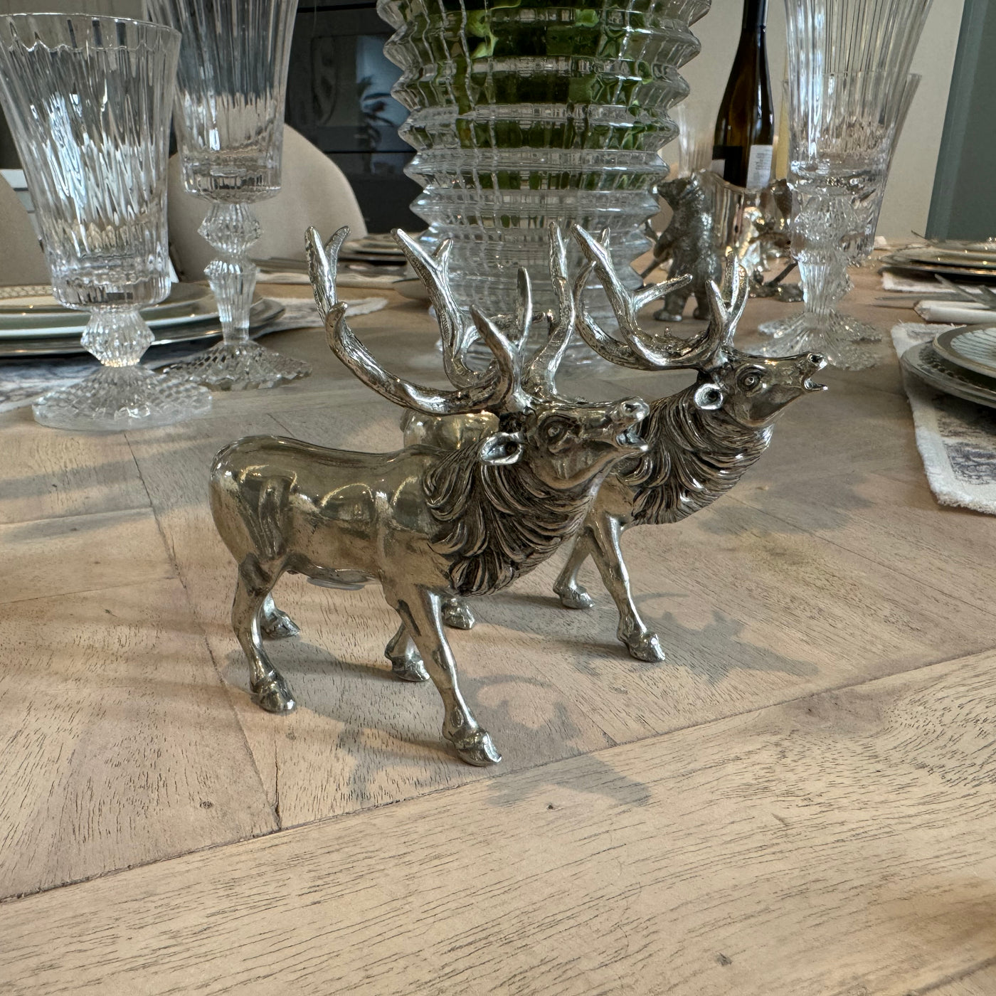 Pewter roaring stag salt and pepper shakers with raised heads on a dining table