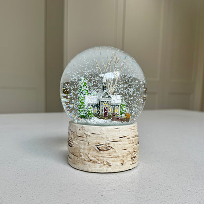 Colourful snowy winter house Christmas snow globe