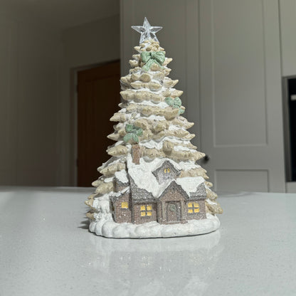 LED Christmas cottage beneath snowy tree with illuminated star