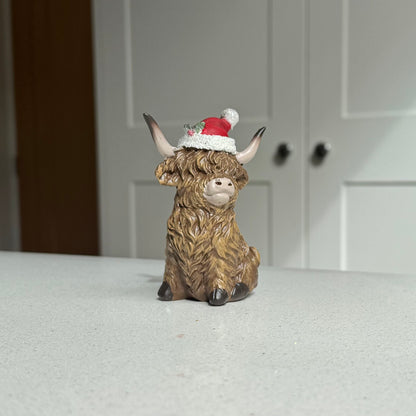 Sitting Highland Cow Ornament with Santa Hat – 9.5cm