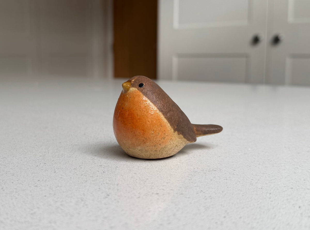 Small resting orange-breasted ceramic robin