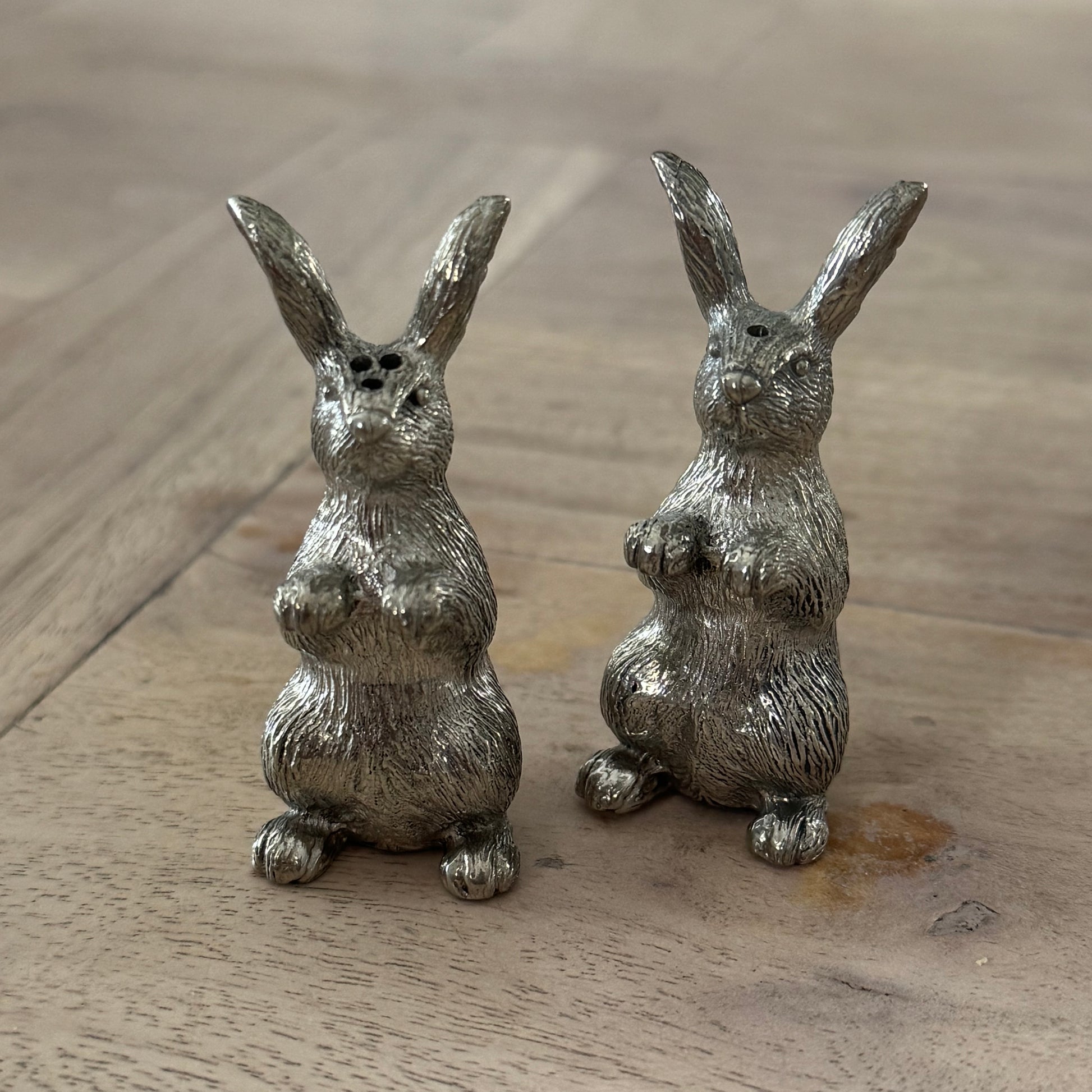 Pair of upright pewter rabbit shakers with textured fur and long ears