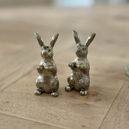 Close-up of the miniature pewter rabbit shaker pair on a wooden table