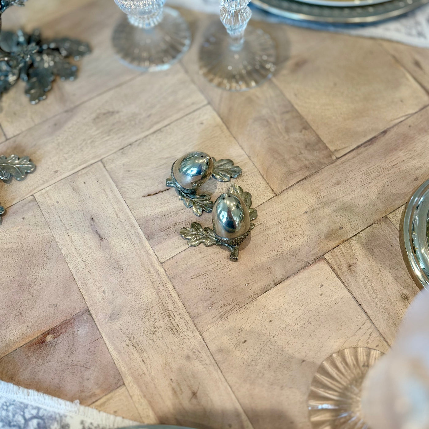 Overhead view of the pewter acorn shaker pair beside a table setting