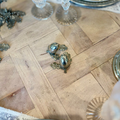 Overhead view of the pewter acorn shaker pair beside a table setting