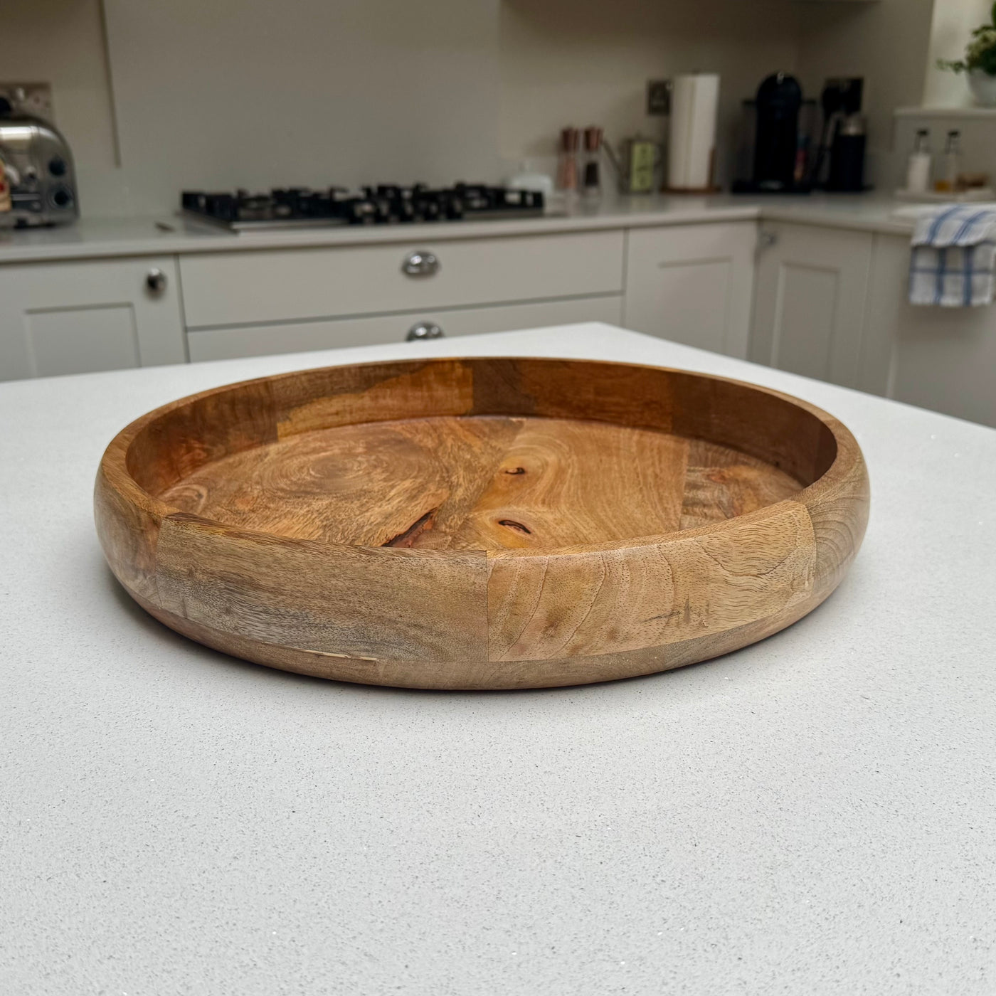 Round natural wood serving tray with raised rim