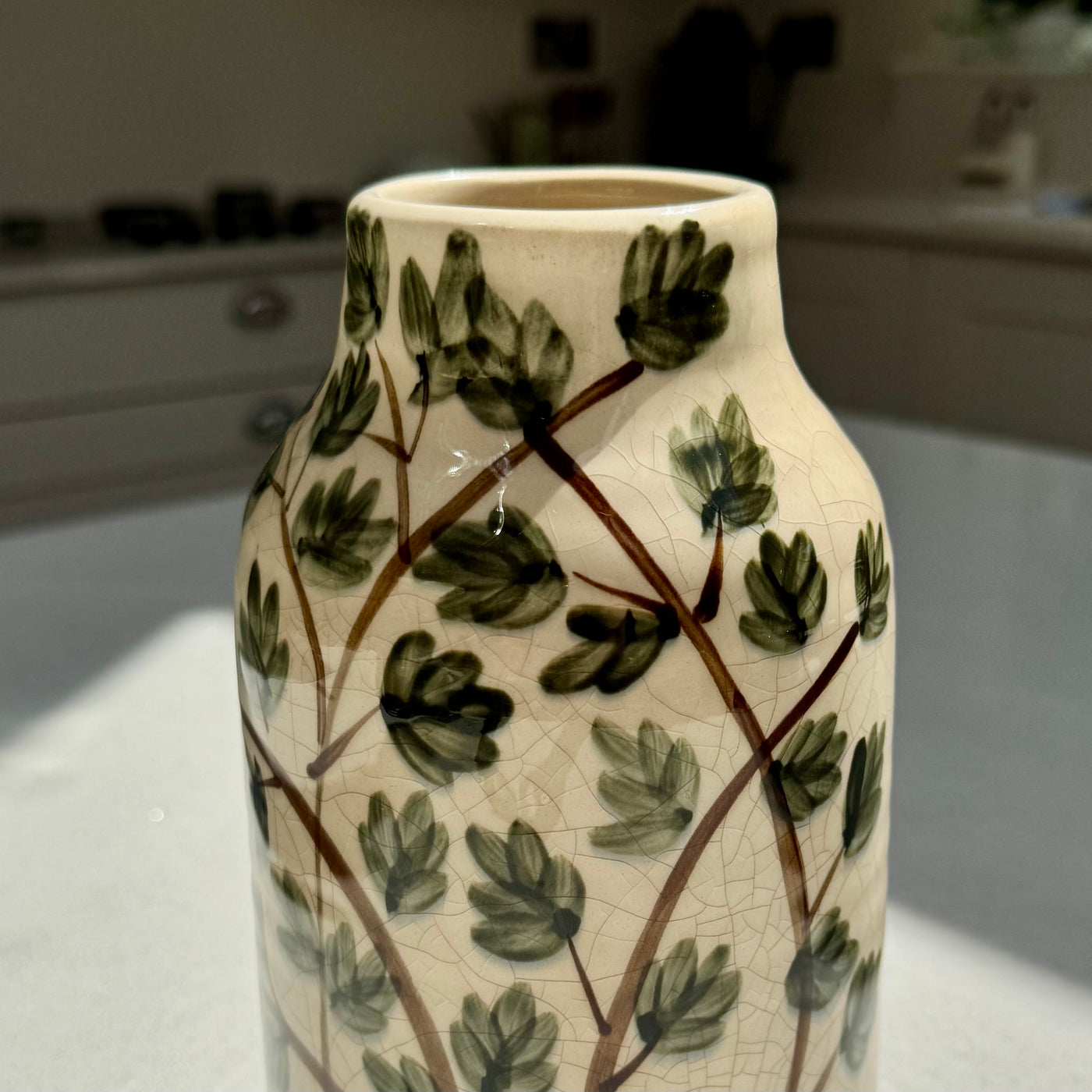 Cream ceramic botanical vase with green leaf detail