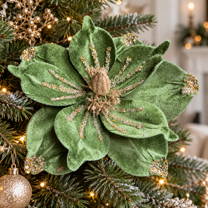 Jade green velvet poinsettia with gold glitter and sequins nestled among Christmas tree branches.